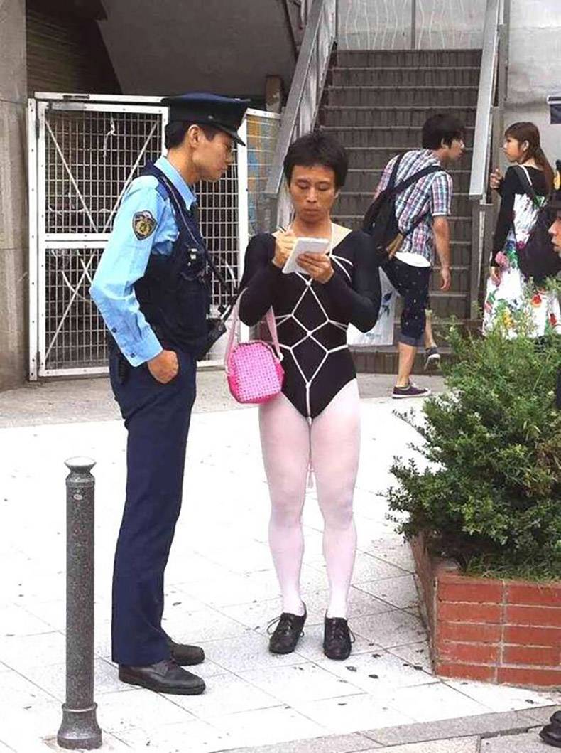 Strangely dressed woman writing a ticket to a cop.