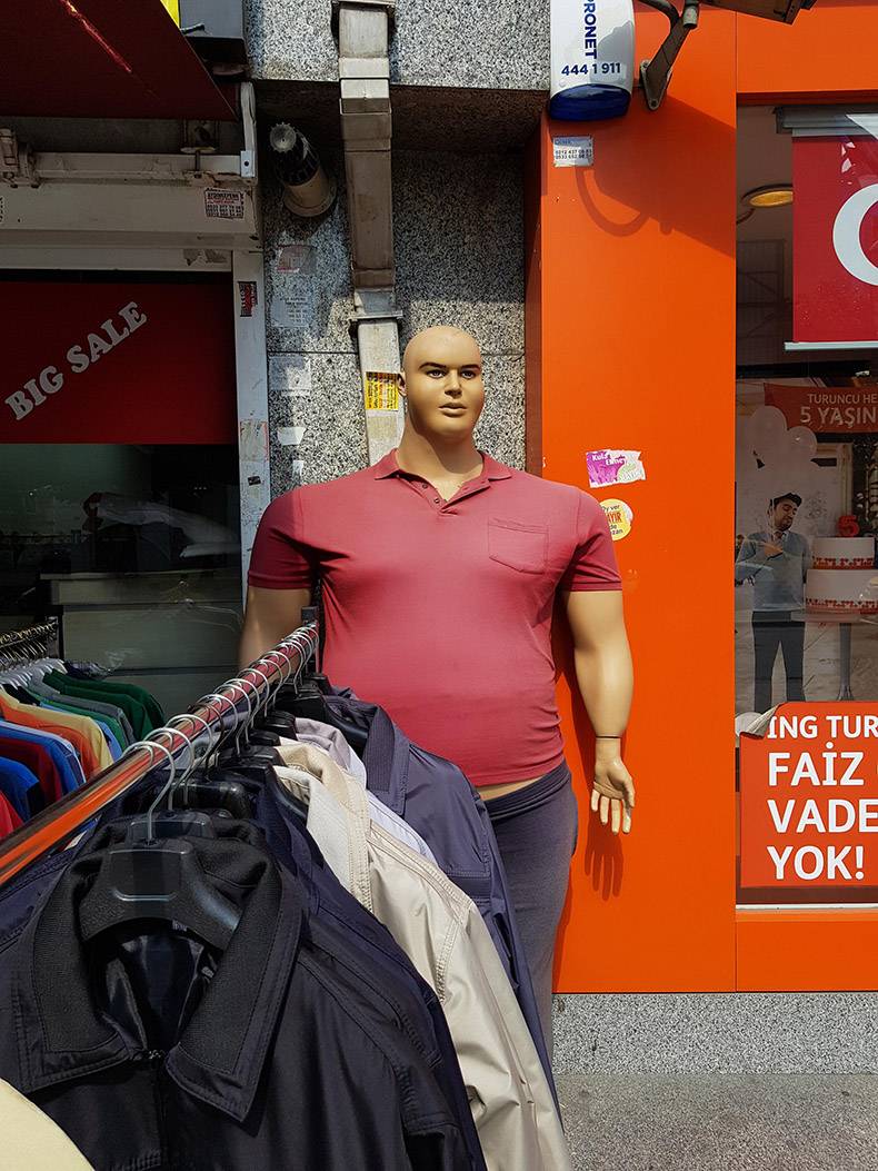 Very wide and large mannequin man in a store.
