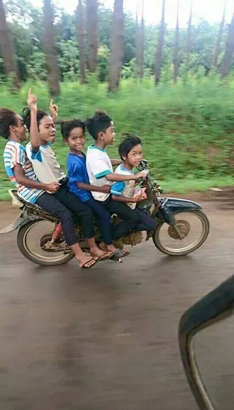 5 kids riding on a moped by themselves.