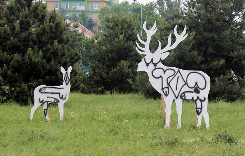 Cutouts of moose and deer spray painted over with real immature symbols.