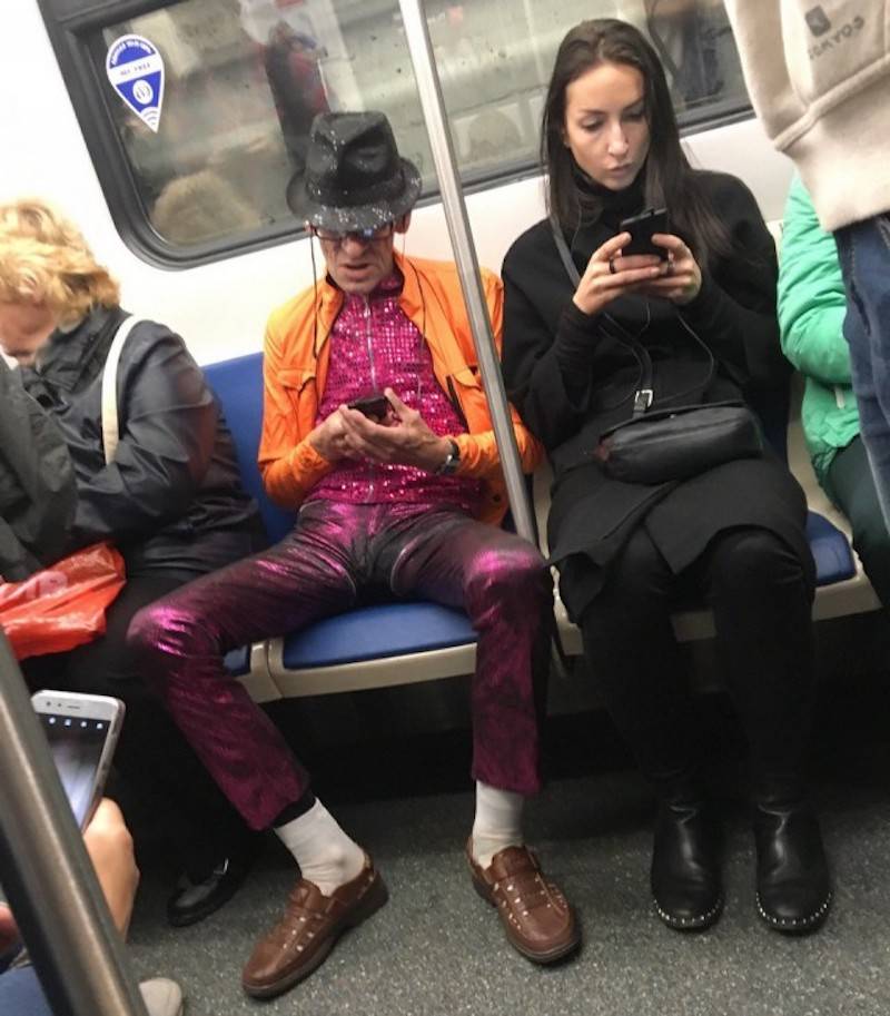 man dressed in flashy outfit on the subway