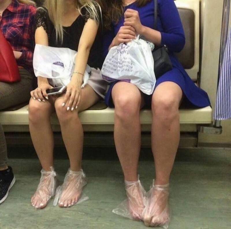 Girls on the subway in nice dresses and wearing plastic bags on their feet.