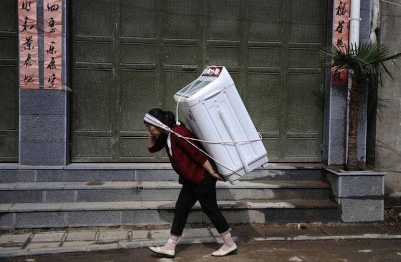 woman carrying washing machine -