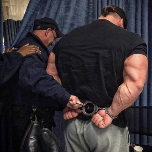 funny bodybuilding guy with huge muscles squeezed into tiny police handcuffs