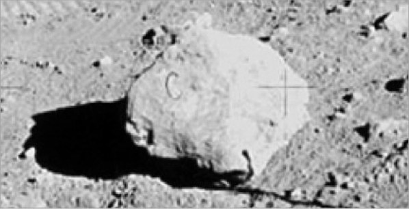 The C Rock
One of the most famous photos from the moon landings shows a rock in the foreground, with what appears to be the letter C engraved into it. The letter appears to be almost perfectly symmetrical, meaning it is unlikely to be a natural occurrence. It has been suggested that the rock is simply a prop, with the C used as a marker by an alleged film crew. A set designer could have turned the rock the wrong way, accidentally exposing the marking to the camera.