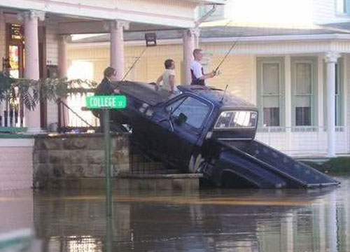 funny picture of keeping the pick up truck out of the floor water by driving it up the porce