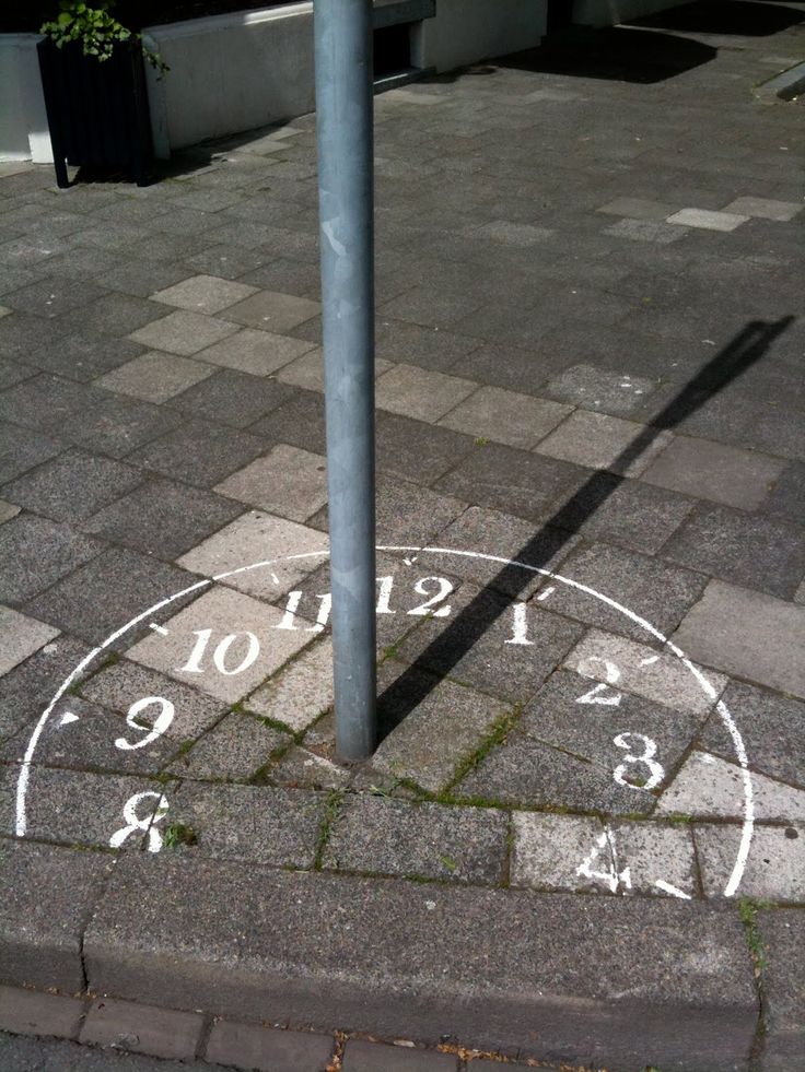 Sundial clock drawn around a pole casting it's own shadow