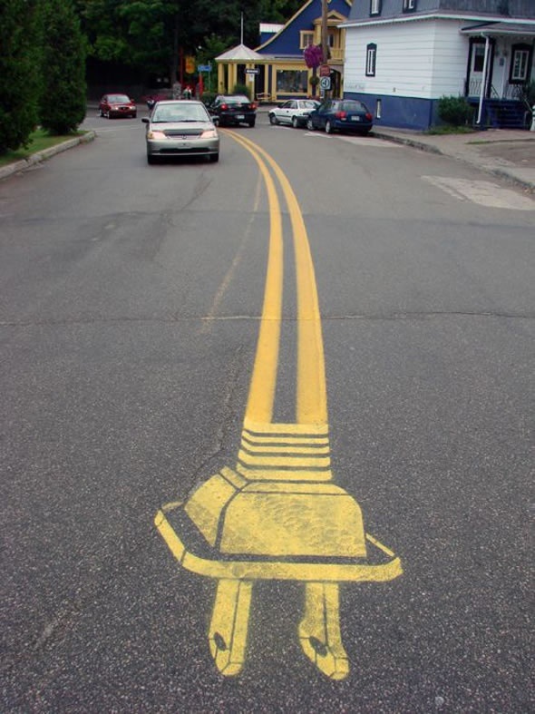 Creative finish to a double yellow line road separator made too look like an electrical cord.