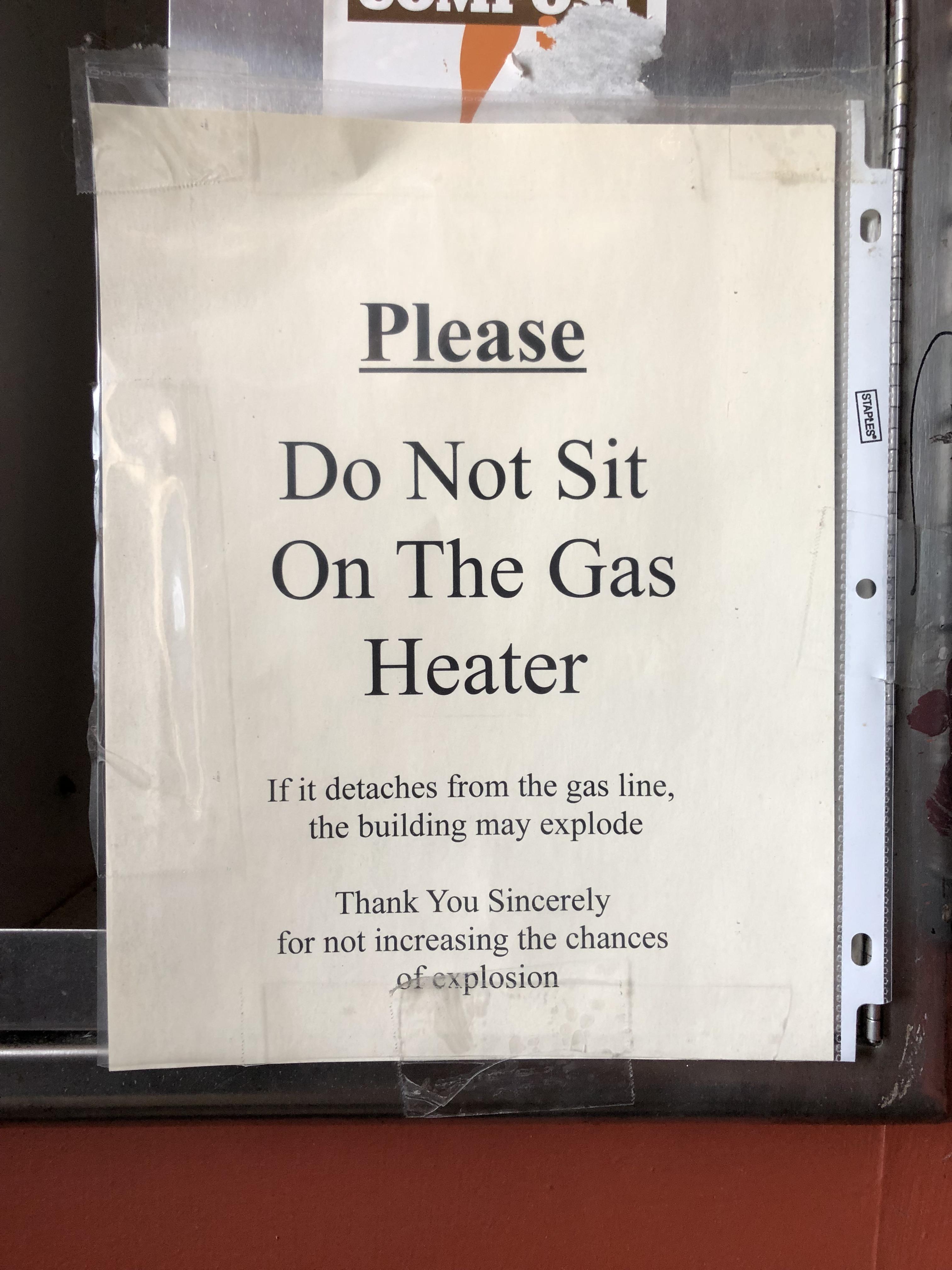 sign - Please Do Not Sit On The Gas Heater If it detaches from the gas line, the building may explode Thank You Sincerely for not increasing the chances of explosion