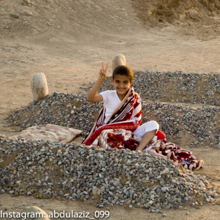 Reality: A staged shot taken by a photographer in Saudi Arabia as part of a conceptual art project. The graves were fake, and the boy was the photographer's nephew. When the photographer realized that the photo was being misunderstood, he uploaded more photos showing other shots of his nephew during the photo shoot, to demonstrate that the scene was a staged art project.