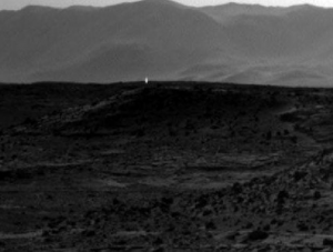 Bright white light in the distance on the surface of Mars
