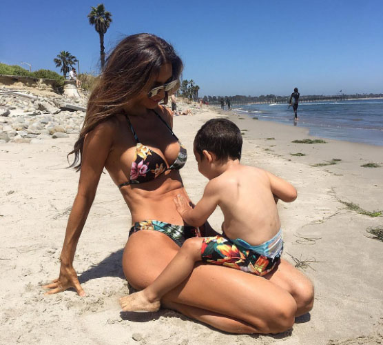 Photo of Sarah Stage sitting on the beach with her son.