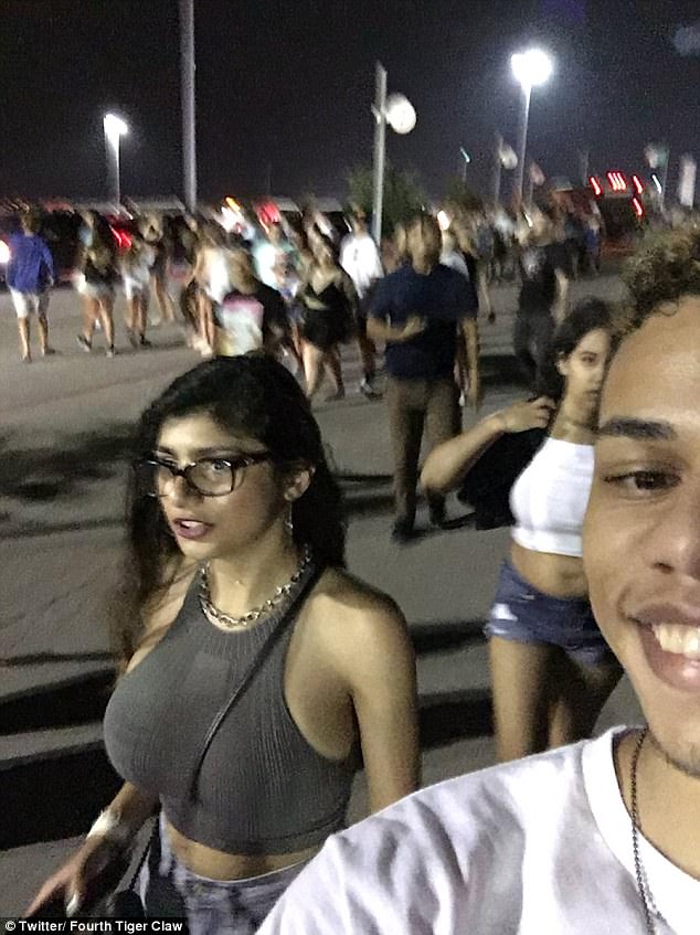 Famous selfie someone took next to Mia Khalifa that got him punched for doing so.