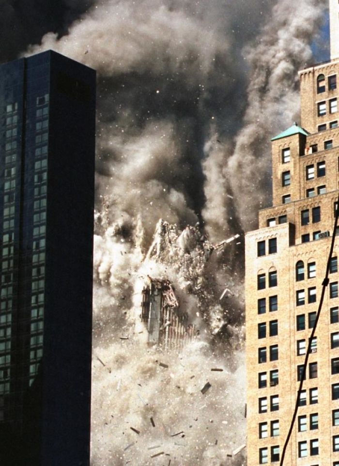 9/11 photo of the tower coming down framed between 2 buildings in the foreground
