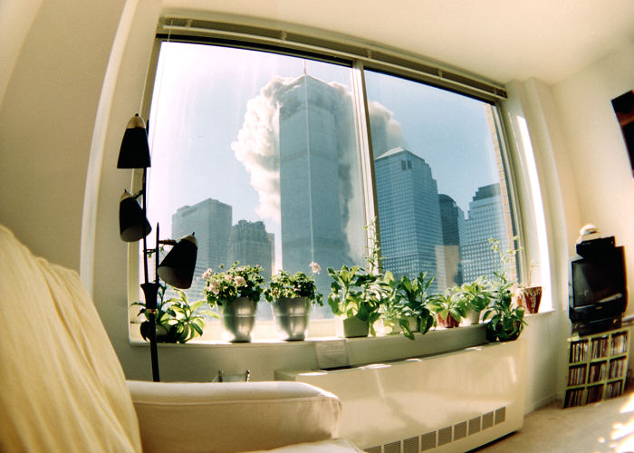 Wide angle pic from someone's living room of the World Trade Center coming down.