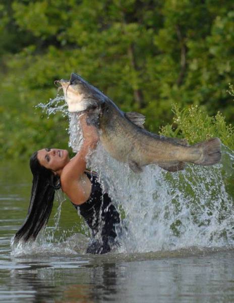 Girl wrestling in the water with a giant fish.