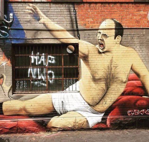 George Costanza posting in his boxer drawers graffiti on the side of a building.