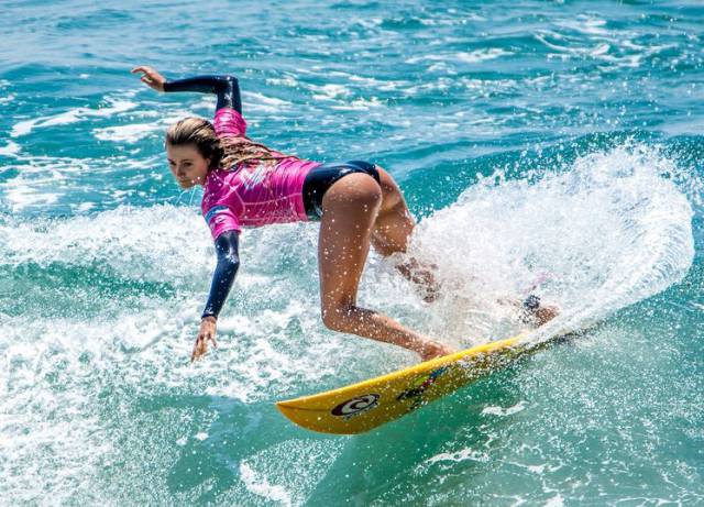 Girl surfing and cutting up the waves.
