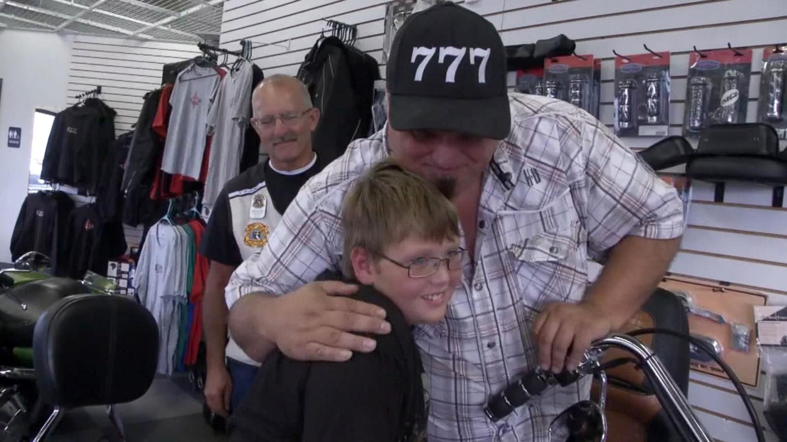 11 year old Phil Mick getting hug from man wearing 777 hat.