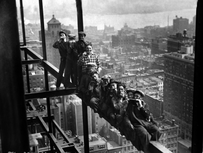 Construction workers take a break and play harmonicas while building the Rockefeller Center skyscraper in NYC in 1932.