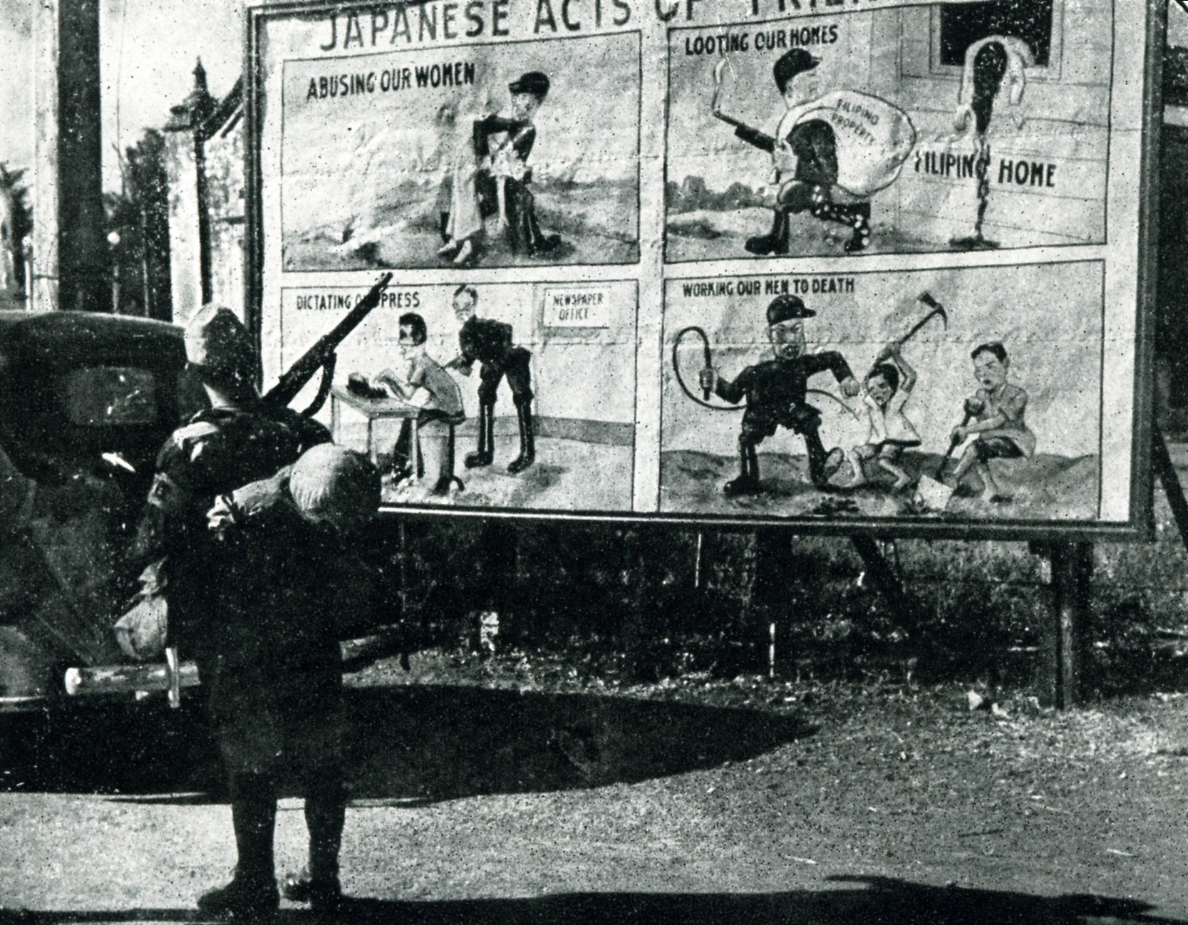 A Japanese soldier stares at a US propaganda poster in Manila, Philippines in 1942.