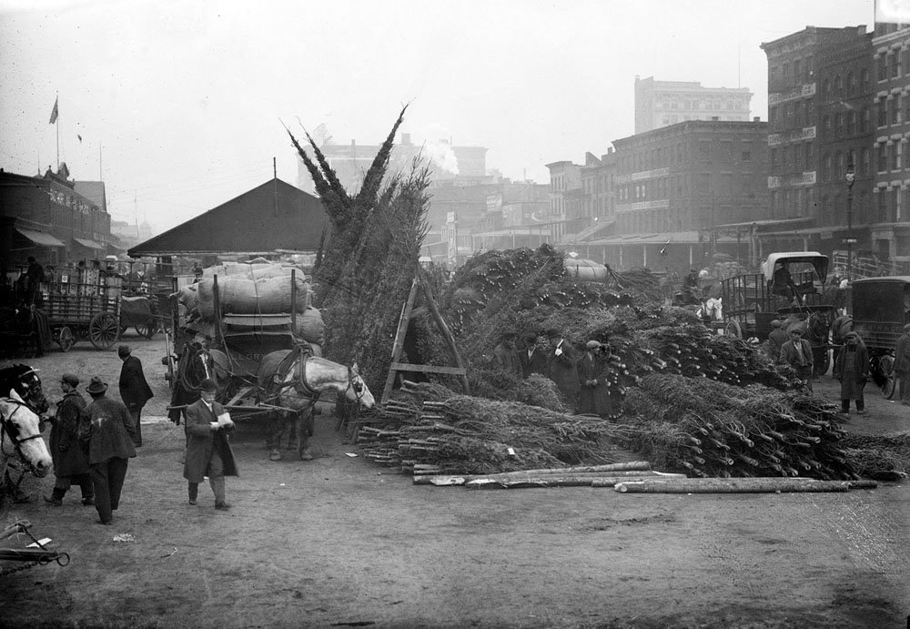 The annual Christmas tree market which was held on West Street across from Pier 21, near Duane Street, New York City, between 1910 and 1915.