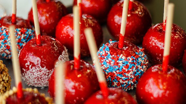 Candy Apples
The history on this one is a little backwards; instead of using the candy to entice people to eat more fruit, it was actually using the fruit to get people to eat candy.
In 1908, William Kolb of New Jersey, wanted to get people to try his cinnamon candy, and he figured coating an apple with it, would get people to but the candy. Much to his surprise, people liked both and now variations of the concept are all over the world, but the most popular is still the fire engine red candy on a red apple.