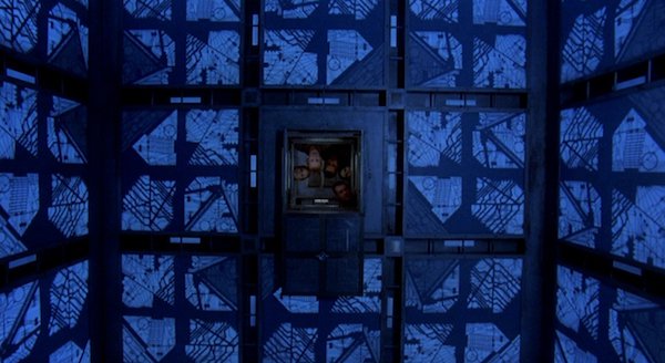 Cube (1997)
This is a pretty messed up film from Canadian director Vincenzo Natali, but man, I do love it! It’s a winning combo of high-concept and low budget, but the story behind it is pretty terrifying.
In this film, a small group of strangers wake up in an elaborate prison maze made up of cubes, with traps, with no memory of how, or why, they’re there. Each cube is booby trapped and they need to learn to trust one another, but as the game goes on, they start to unravel. This one is a much watch if you have a soft spot for claustrophobic, psychological horror.