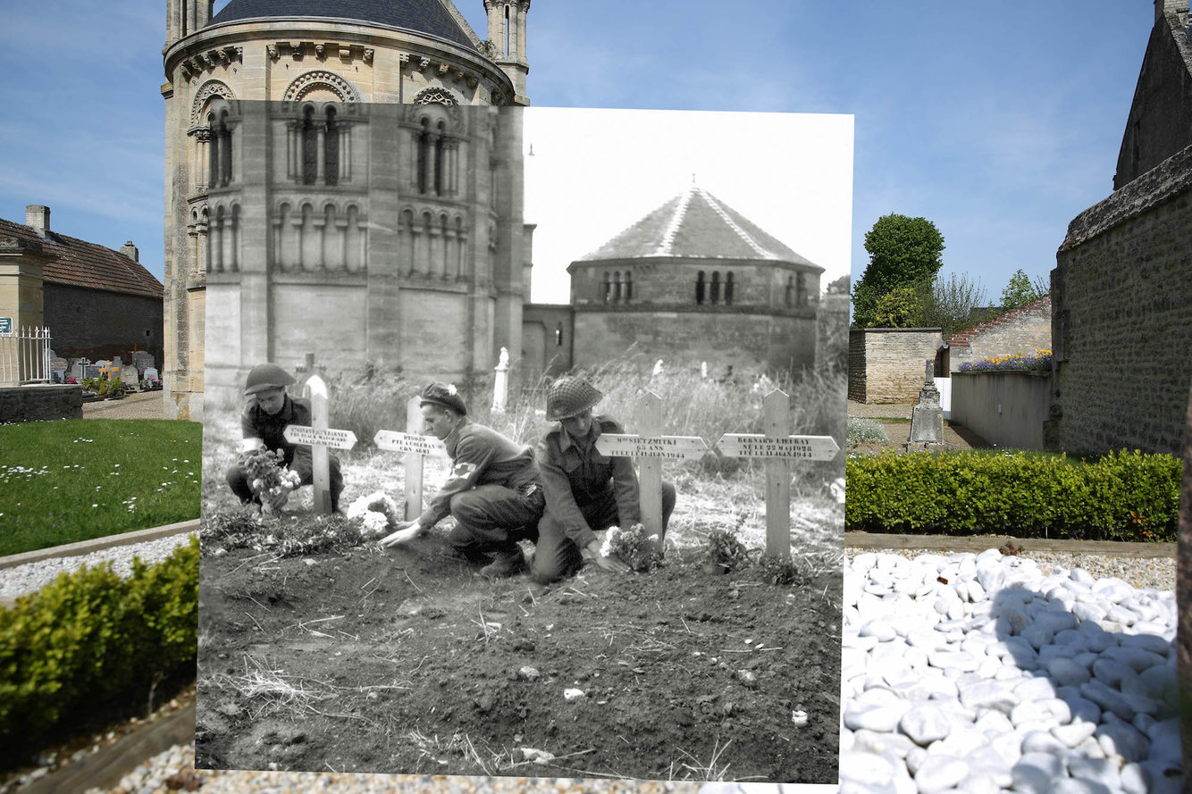 The graveyard with the church of Saint Georges de Basly in the background on May 5, 2014, in Basly, France, seen juxtaposed with three soldiers of the 23rd Field Ambulance of the 3rd Canadian Infantry Division placing flowers on graves.