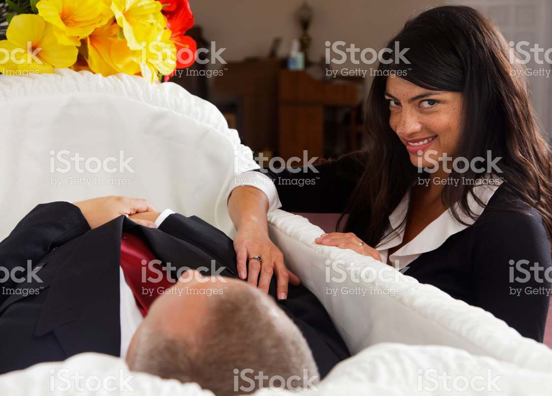 Girl at open casket at a funeral giving strange smile to the camera