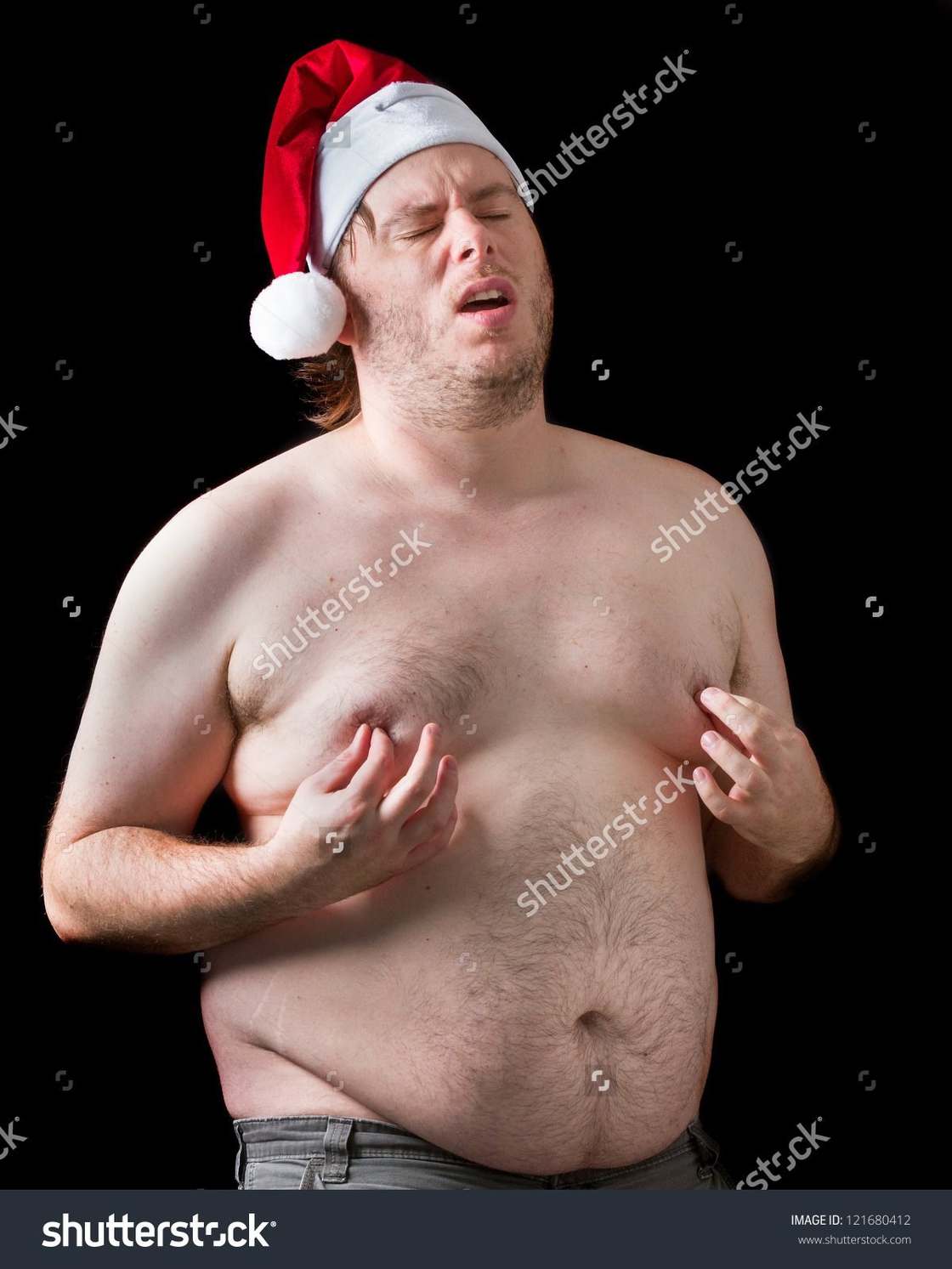 Fat man wearing Santa Clause hat and pinching his nipples while showing euphoric agony on his face.
