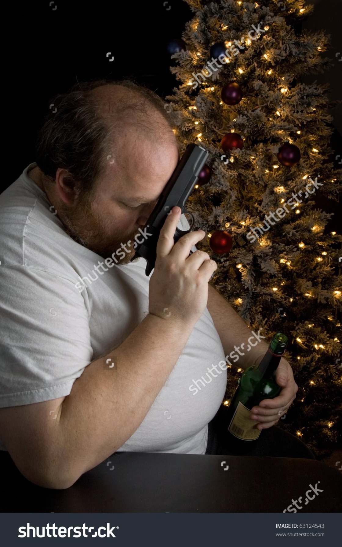 Fat man by a Christmas tree saying a prayer with a gun