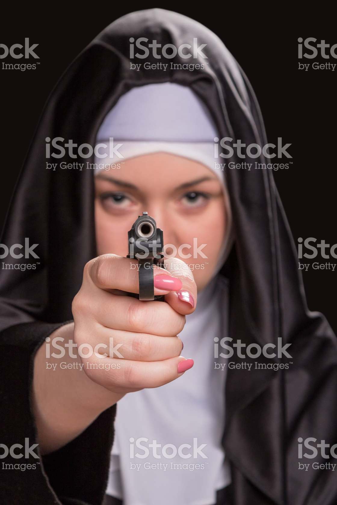 nun pointing a gun at the camera