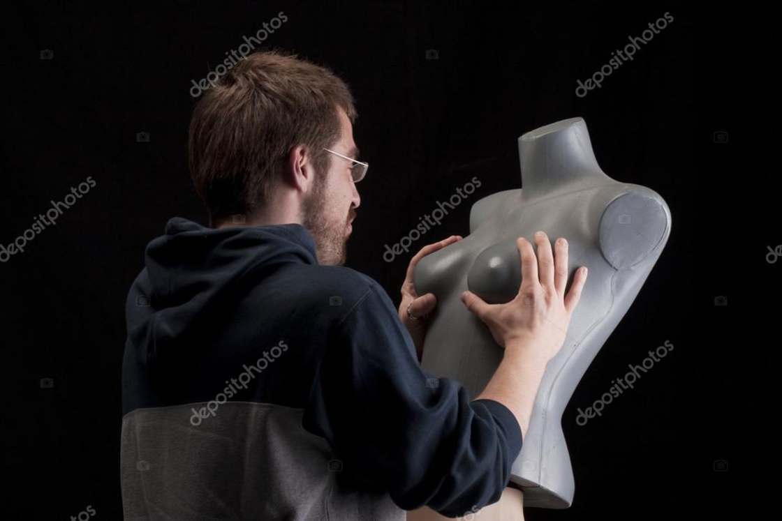 man groping the bust of a mannequin