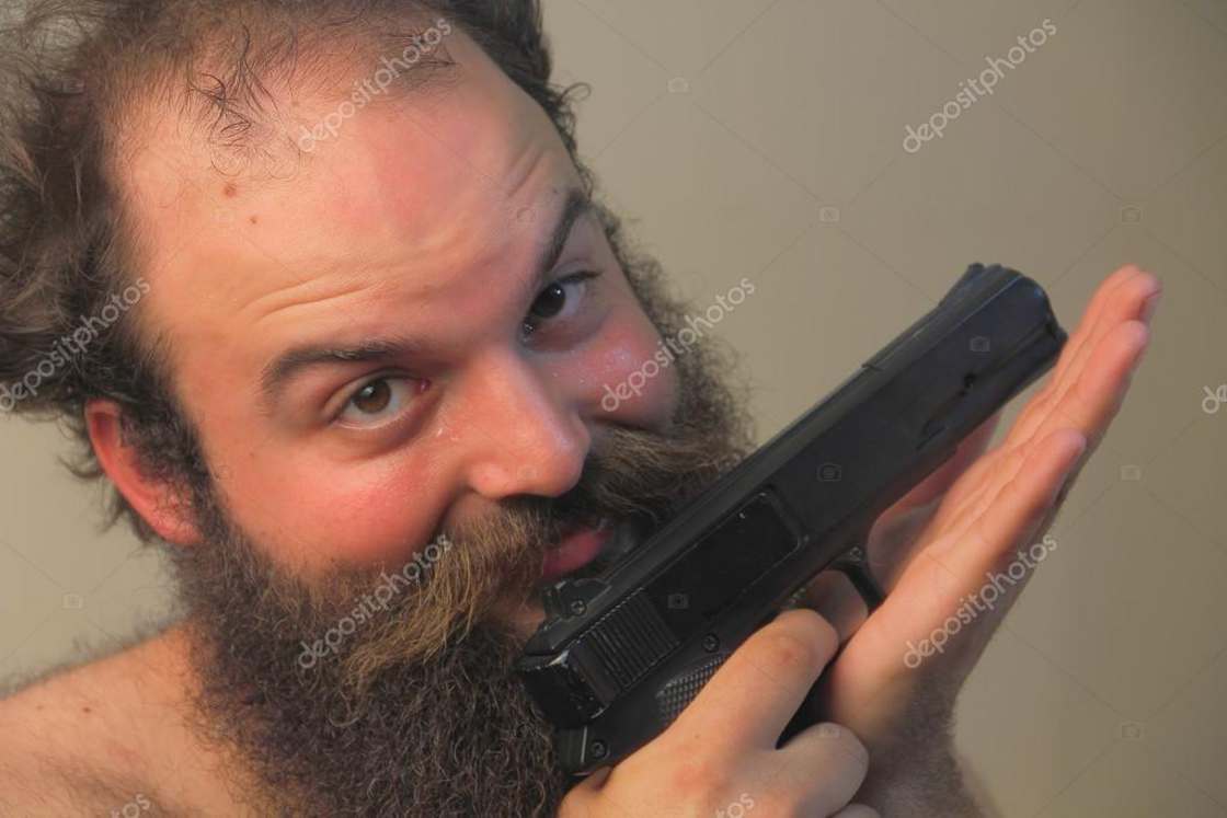Strange bearded man caressing his 9mm gun