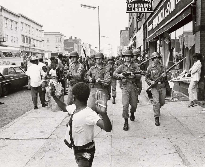 Michigan National Guardsman move down a looted street as a small boy shows he is not armed during the destructive riots in Detroit, US in 1967. The riots started with a police crackdown, which resulted in a huge respond from the black communities. This was during a time of heavy racial tensions in the US. In fact, in the summer of 1967 alone, 159 documented race riots occurred throughout the country. This one was the worst.