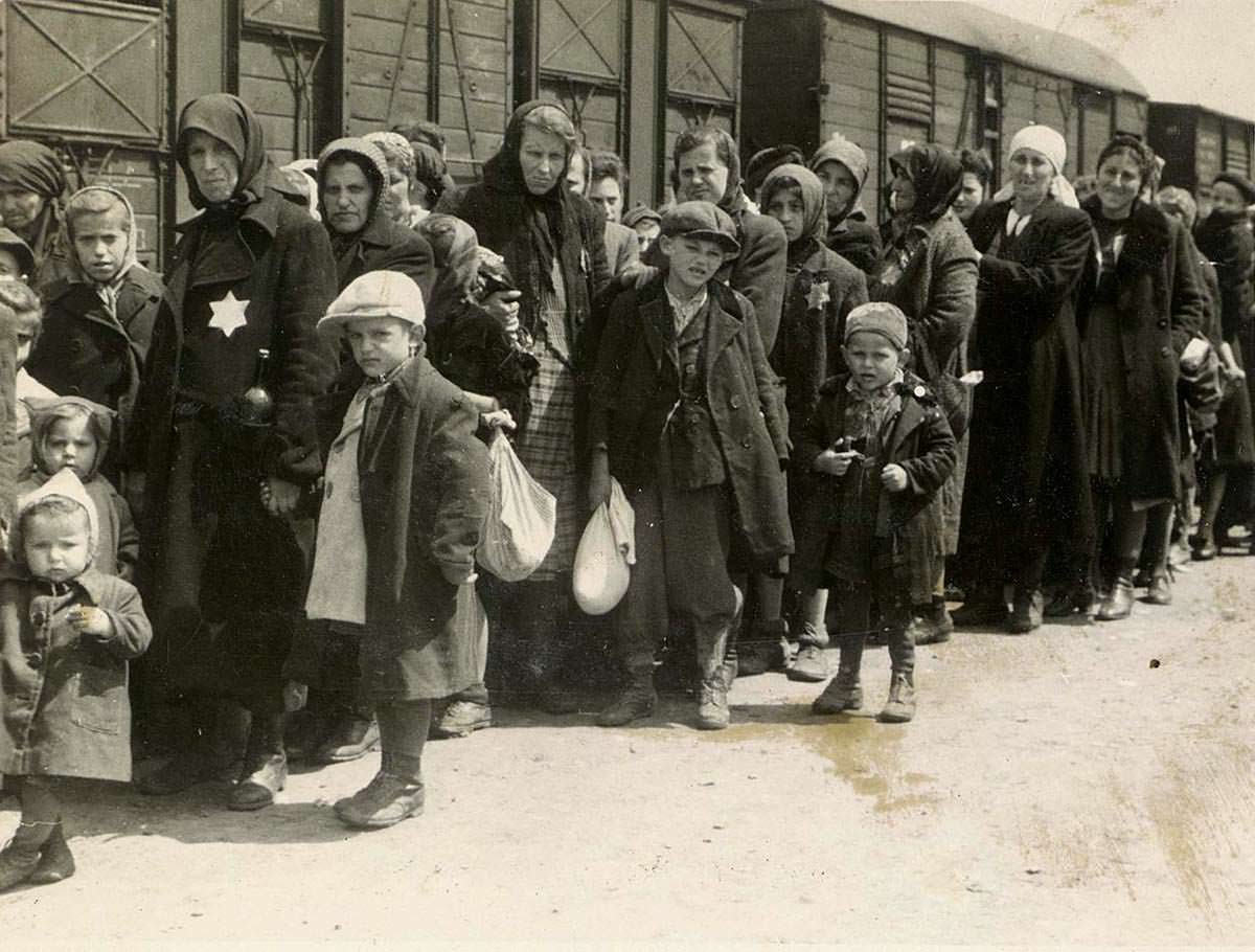 Jewish women and children arrive at Auschwitz Concentration Camp from Hungary in 1944. The men had either already been separated for work camps or killed. Hungary before this was a member of the Axis powers, but Germany feared they would switch sides and invaded and took them over in early 1944. Up until then, Hungary only sent a small portion of their Jewish population to Nazi control, around 50,000 total in 4 years. After the takeover, the Nazi's sent every Jew they could in Hungary to Auschwitz. Within 1 year of occupying Hungary, the Nazi's shipped out some 500,000 Hungarian Jews to be gassed. They ramped up the process even as the war was lost to kill as many as possible. Jews, such as these pictured, would be put on a train straight from a ghetto, then spend hours heading to Auschwitz. Once there, they would get right off the train, lead into a changing room, stripped, moved into a gas chamber disguised as a shower, and killed. This process ran day and night right up to the week the camp was liberated in 1945. This picture is taken by an SS officer for an album, and sadly, every single person in the picture would be dead within an hour of it being taken.