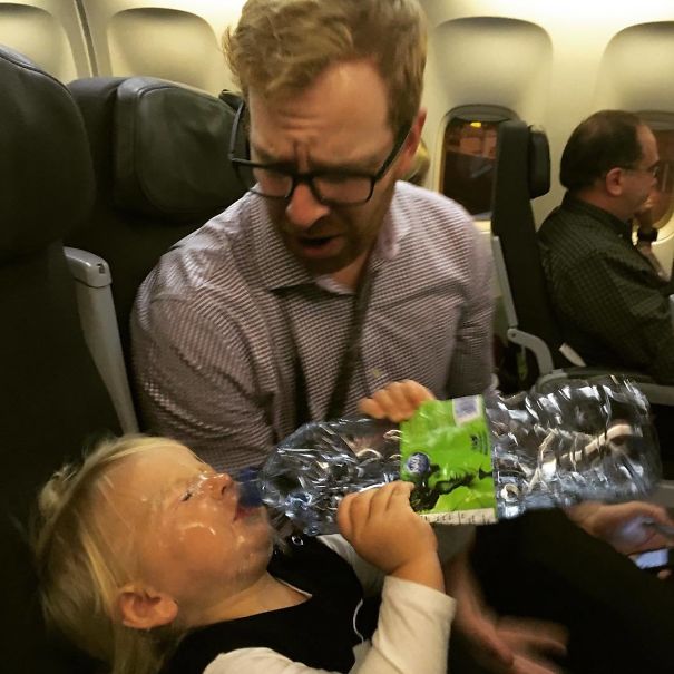 daughter drinking water on an airplane and it spills all over her face
