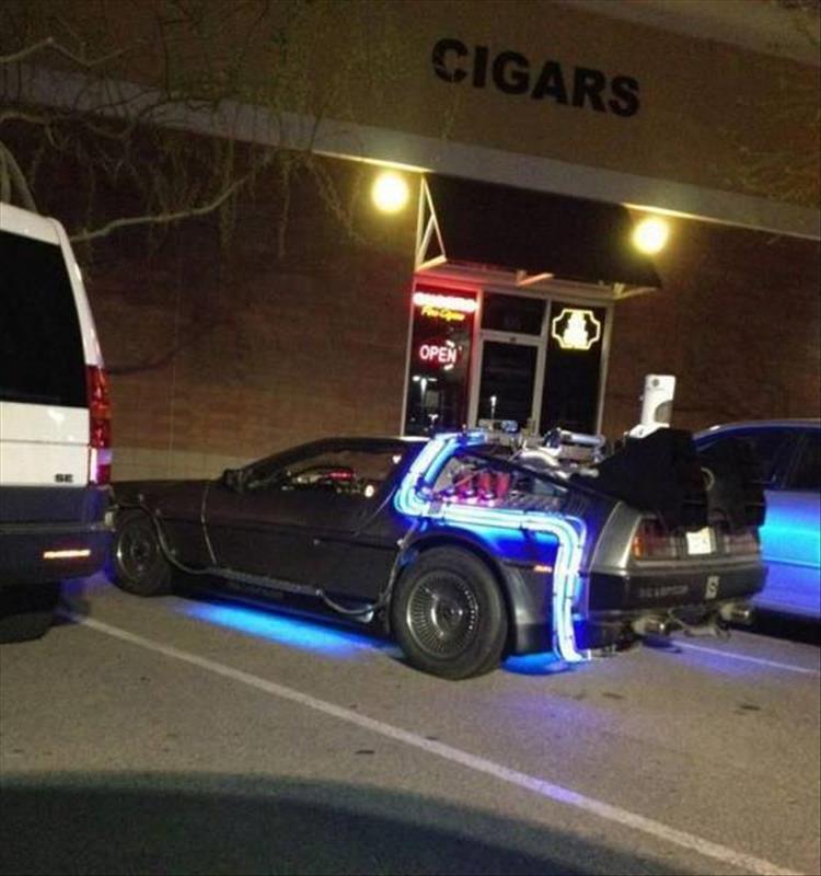 random picture of a modified delorean car made to look like the back to the future version sloppily parked outside a store
