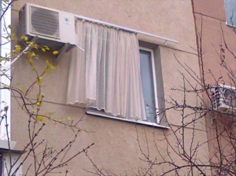 random picture of a set of curtains installed on the wrong side of the window, that being the outside