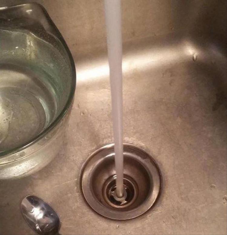 random picture of water perfectly going from the faucet into the drain