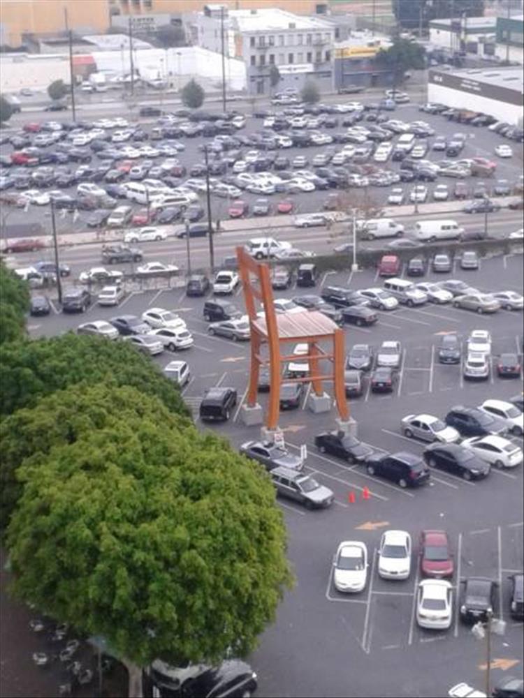 random picture of a massive wooden chair in a parking lot