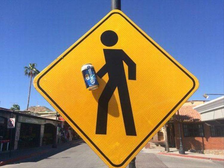 funny random picture of a crosswalk sign with beer can in the stick figure's hand