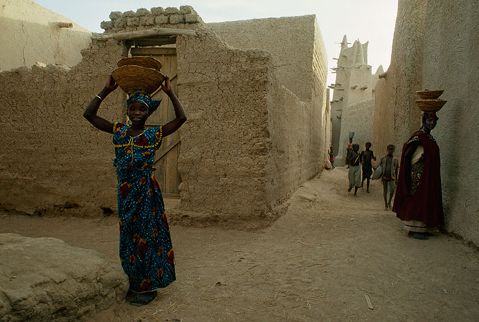 Women carry baskets on their heads while children play in Kotaka, Mali, 1991Image source: James L. Stanfield