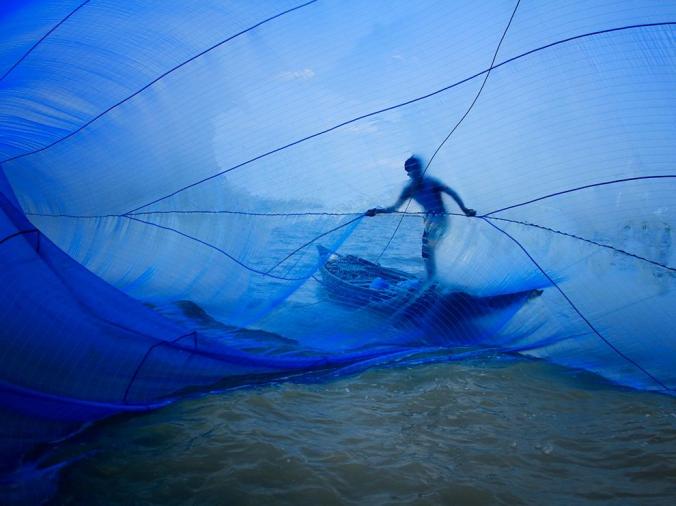 FISHERMAN, BANGLADESH
A Bangladeshi fisherman flings open a traditional blue net to catch tiny shrimp. His village, Gabura, is in southwestern Bangladesh and has been studied for the effects of climate change.
PHOTOGRAPH BY PRONOB GHOSH, NATIONAL GEOGRAPHIC YOUR SHO