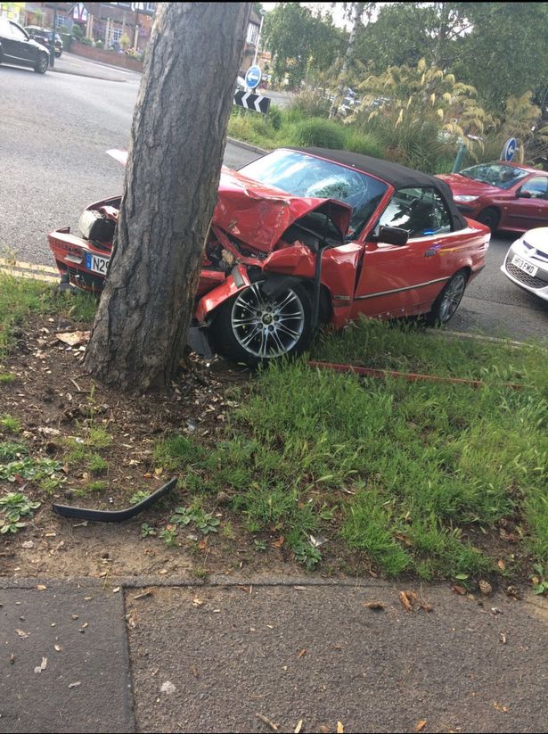 The crumpled BMW convertible after ploughing into a tree