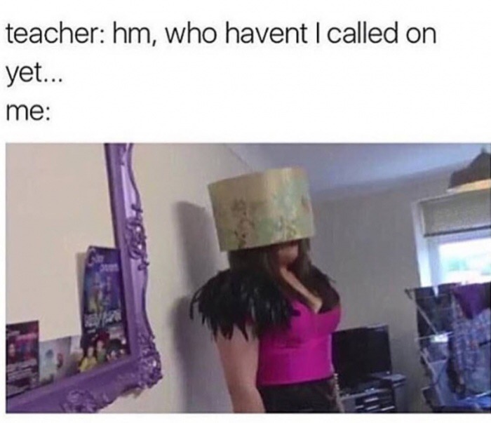 girl hiding under a lamp shade from her teacher to ask a question