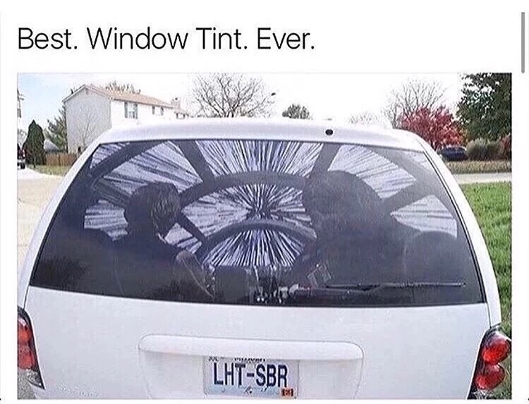 Window tint on the back of a mini-van which looks like Hans Solo and Chewbacca about to kick into hyperspace on their Millennium Falcon.