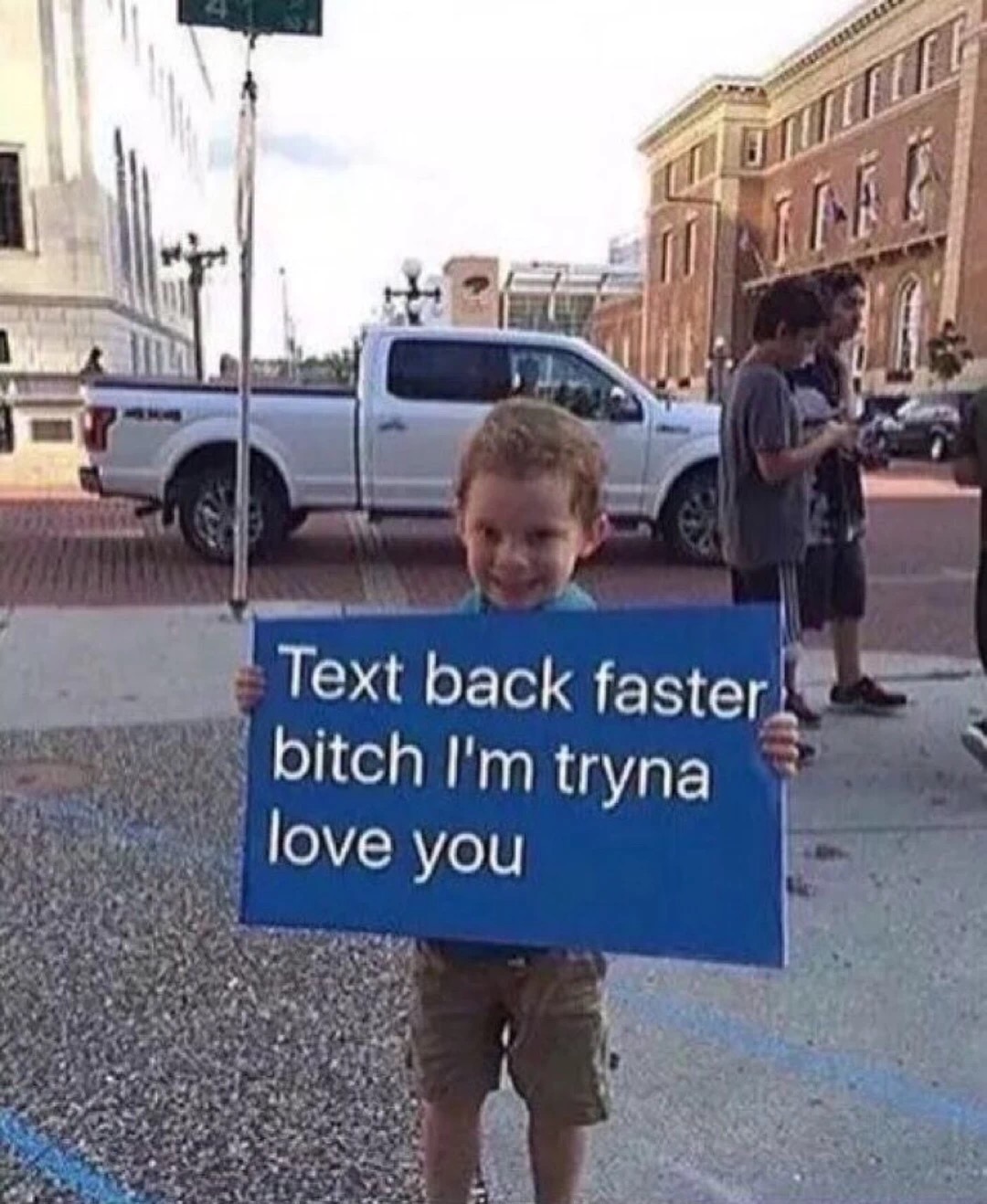 Kid holding up a text sign about telling a girl to write back faster.