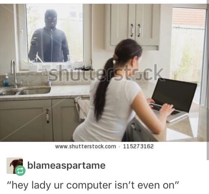 Stock photo of a woman at a computer and man in balaclava outside with caption HEY LADY, UR COMPUTER IS NOT EVEN ON.